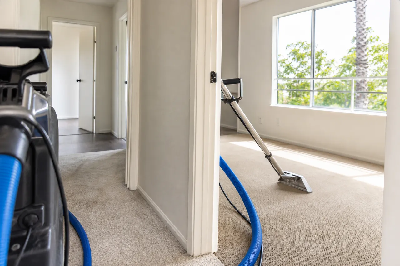 Professional carpet cleaning equipment working through an empty rental unit